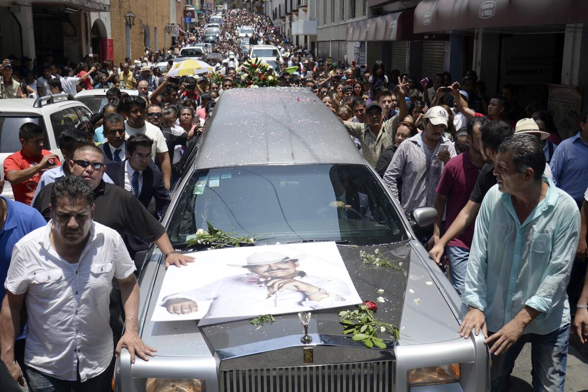 Miles de personas participan en el funeral del cantautor mexicano Joan Sebastian en las calles de Cuernavaca, México, el míercoles 15 de julio de 2015. El músico ganador del Grammy y el Latin Grammy murió el lunes. Era famoso por canciones sentimentales como "Tatuajes" y "Secreto de Amor". Tenía 64 años. (Foto AP/Tony Rivera)