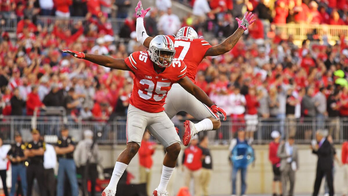 Ohio State's Chris Worley (35) and Damon Webb (7) celebrate after a stop against Indiana in Columbus, Ohio, on Oct. 8.