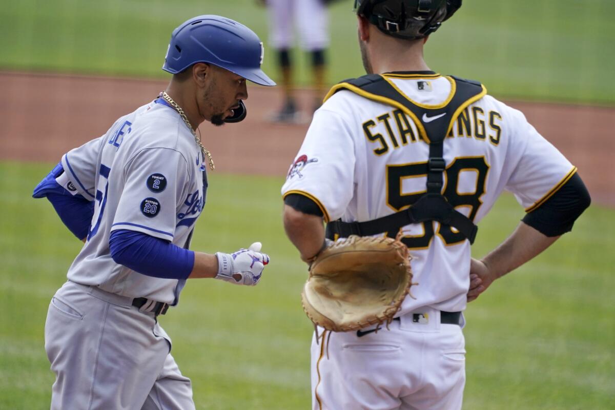 Mookie Betts, left, crosses home plate past Pittsburgh Pirates catcher Jacob Stallings.