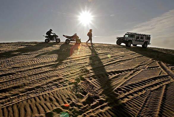 Border Patrol agents on all-terrain vehicles stop to talk with an agent in a Hummer at the Imperial Sand Dunes Recreation Area. The government has so far resisted calls, even from the agents' union, to close part of the dunes.