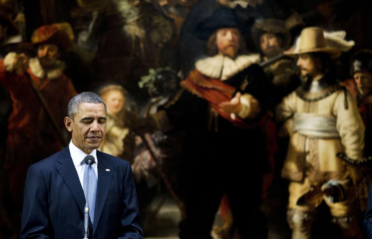 President Obama stands in front of Rembrandt's "Night Watch" during a joint news conference with the Dutch prime minister.
