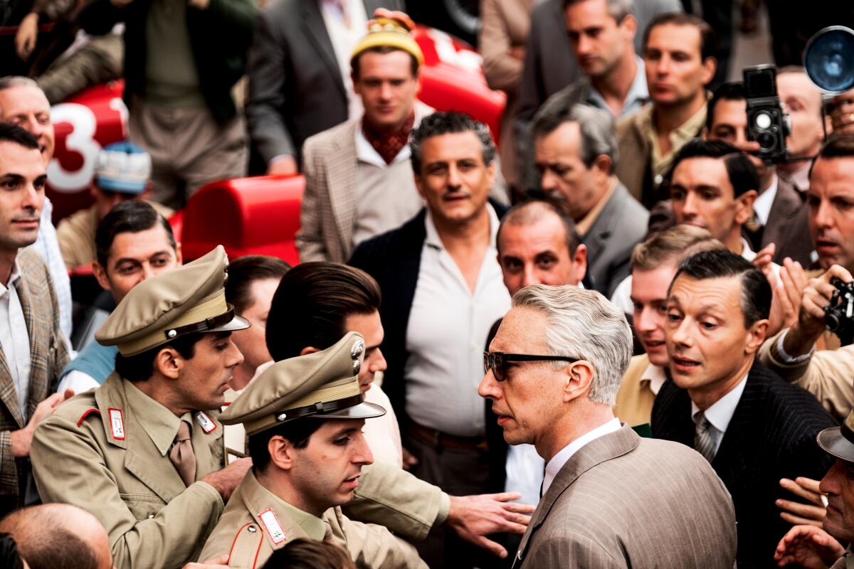 A man in sunglasses makes his way through a crowd.