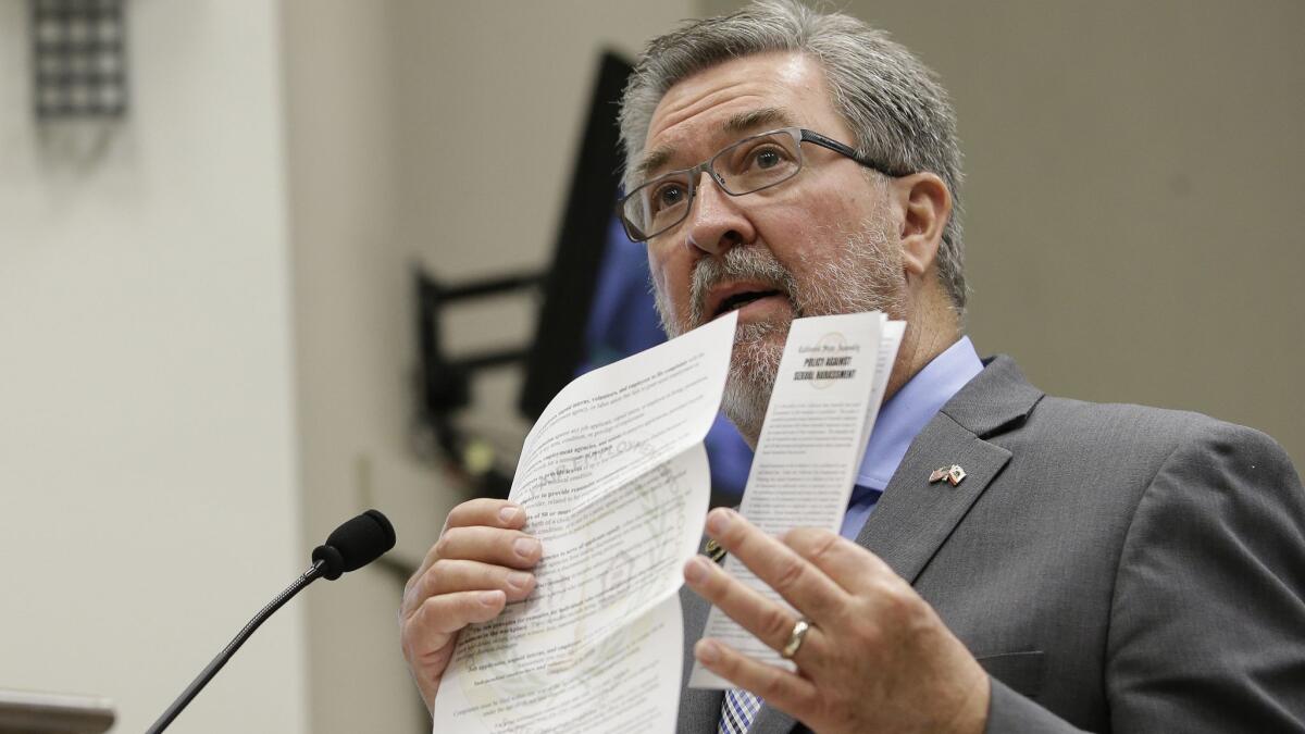 Assembly Rules Committee Chairman Ken Cooley displays sexual harassment documents during a hearing in Sacramento in November.
