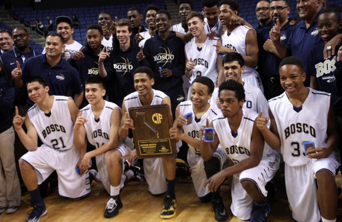 St. John Bosco players pose for a team photo with their championship plaque following their 72-55 win over Compton in the Southern California Regional Division II final at Citizens Business Bank Arena in Ontario on Saturday.