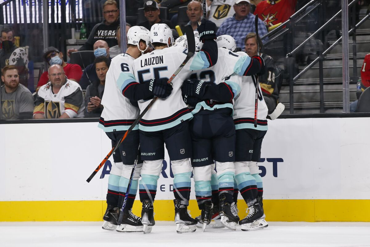 The Seattle Kraken celebrate a goal against the Vegas Golden Knights during the third period of an NHL hockey game Tuesday, Oct. 12, 2021, in Las Vegas. (AP Photo/Chase Stevens)