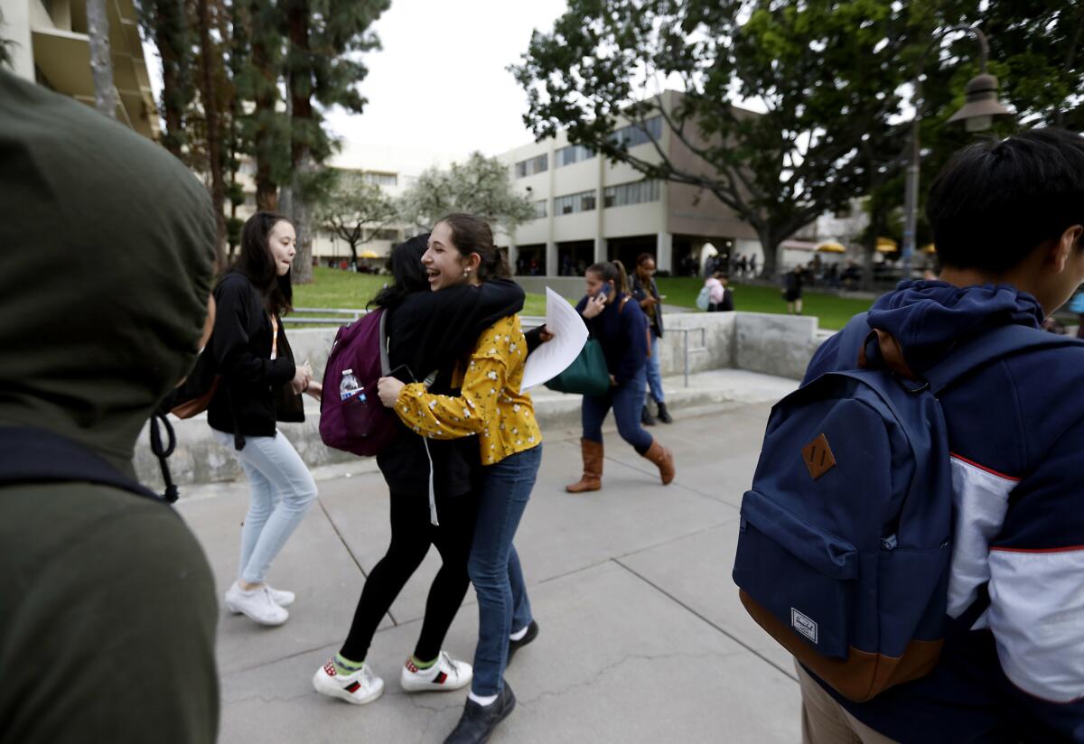 Annsana Biju, 13, left, and Mia Turel, 13, hug at the end of the day on campus. (Francine Orr / Los Angeles Times)