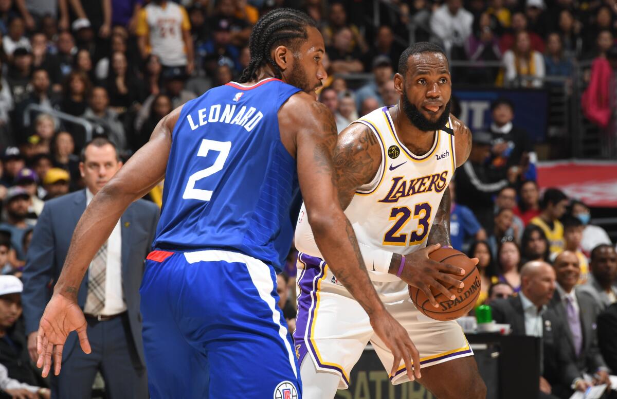 Clippers forward Kawhi Leonard plays defense against Lakers forward LeBron James during a game March 8, 2020.