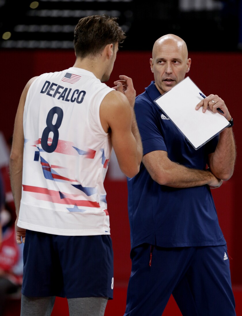 U.S. volleyball player T.J. DeFalco talks to coach John Speraw at the Tokyo Olympics.