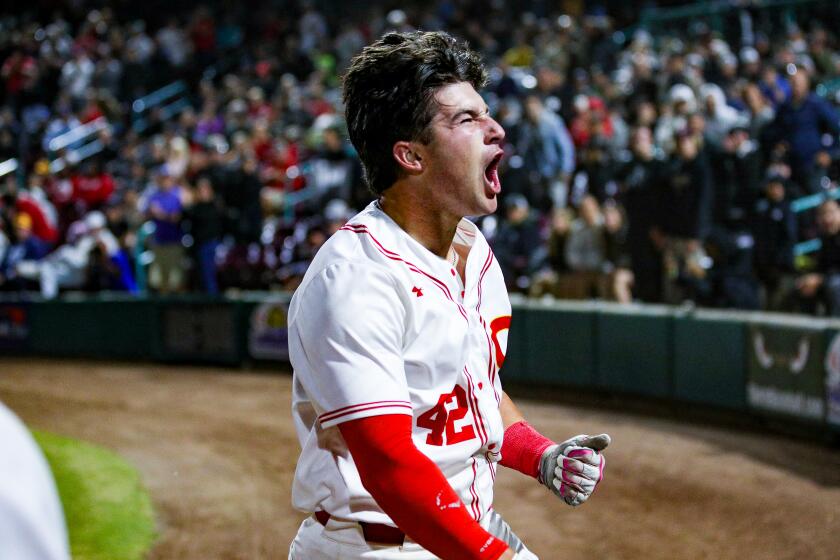 Sam Burgess roars with a primal scream after hitting a three-run home run in the fourth inning for Corona.