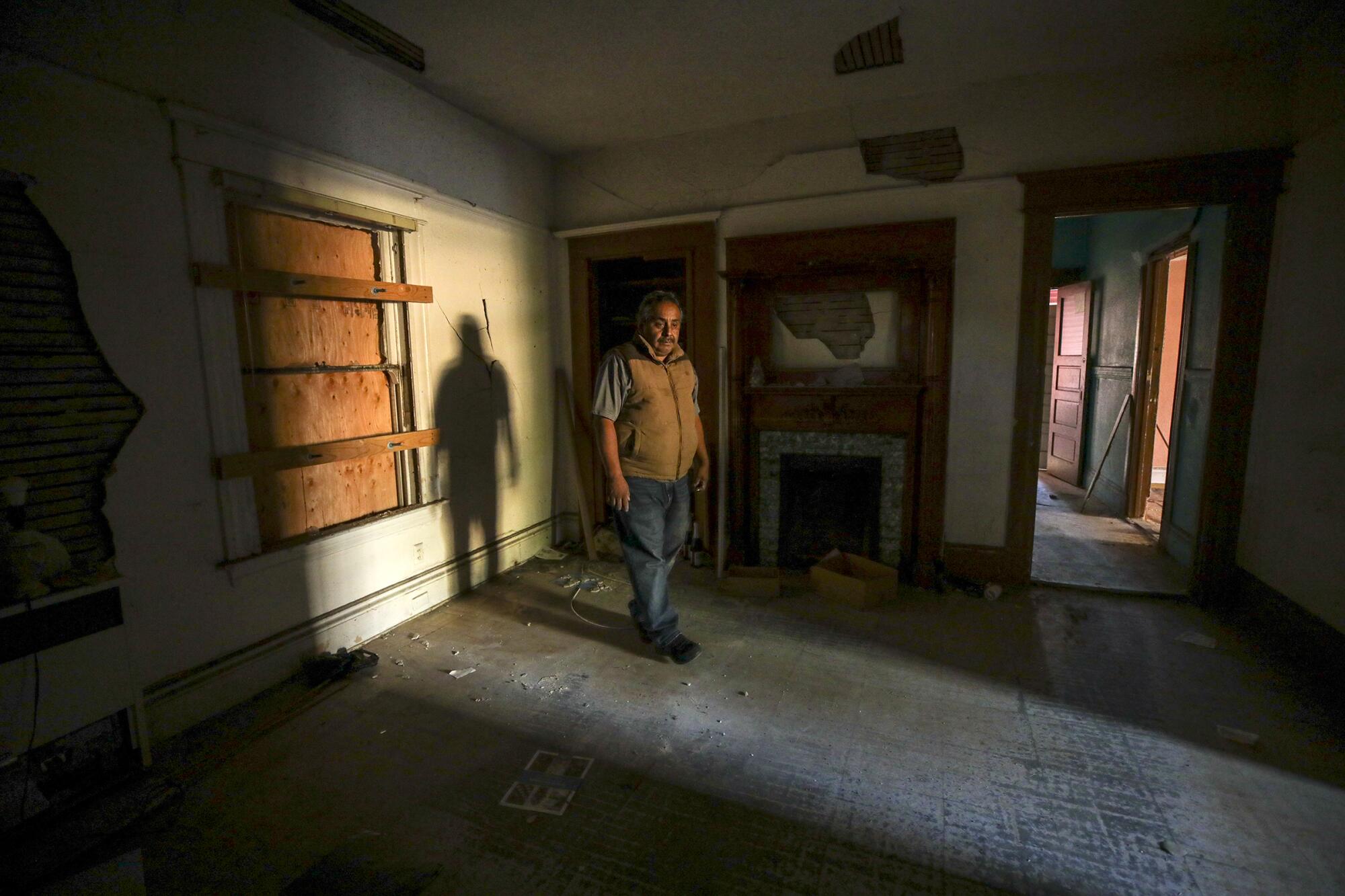 A man stands in a destroyed home.