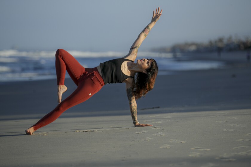 Laura Schwartz strikes a yoga pose on the beach