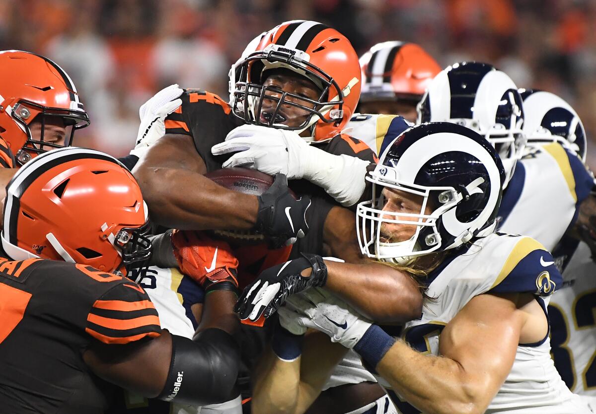 Clay Matthews, right, helps the Rams defense stop Browns running back Nick Chubb on Sunday night in Cleveland.