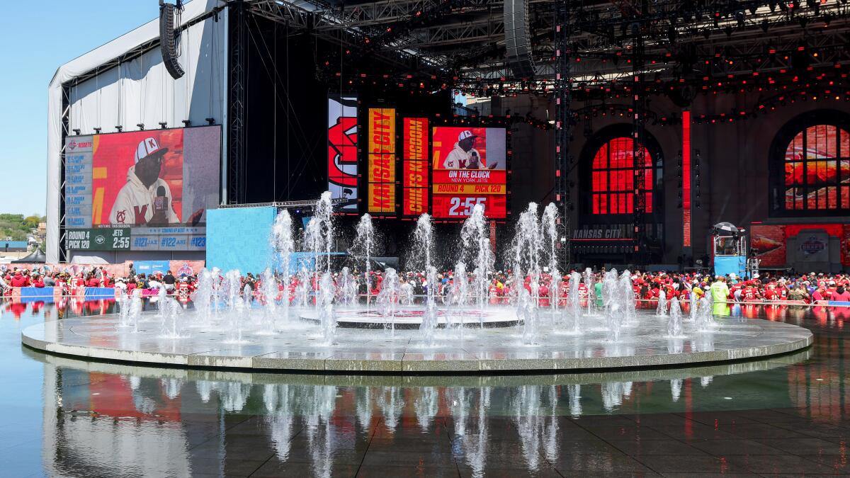Fountains rise in front of the NFL Draft Theatre