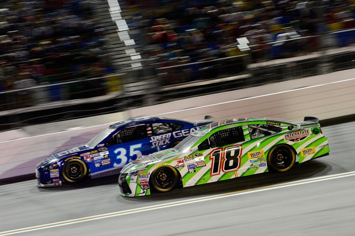 NASCAR drivers Kyle Busch, in the No. 18 car, and Cole Whitt (35) race side by side during the Sprint Cup Coke Zero 400 on Sunday night at Daytona International Raceway.