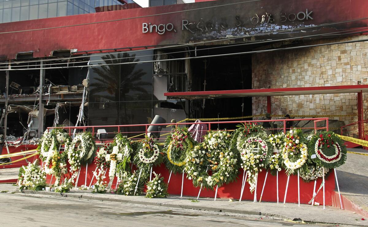 Un memorial improvisado con coronas fúnebres se alinea en la entrada circular del Casino Royale en Monterrey, México