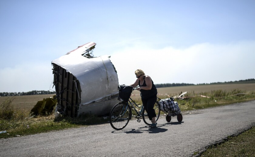 A woman walks her bicycle near wreckage from the crash of Malaysia Airlines Flight 17 in eastern Ukraine's Donetsk region on Aug. 2.