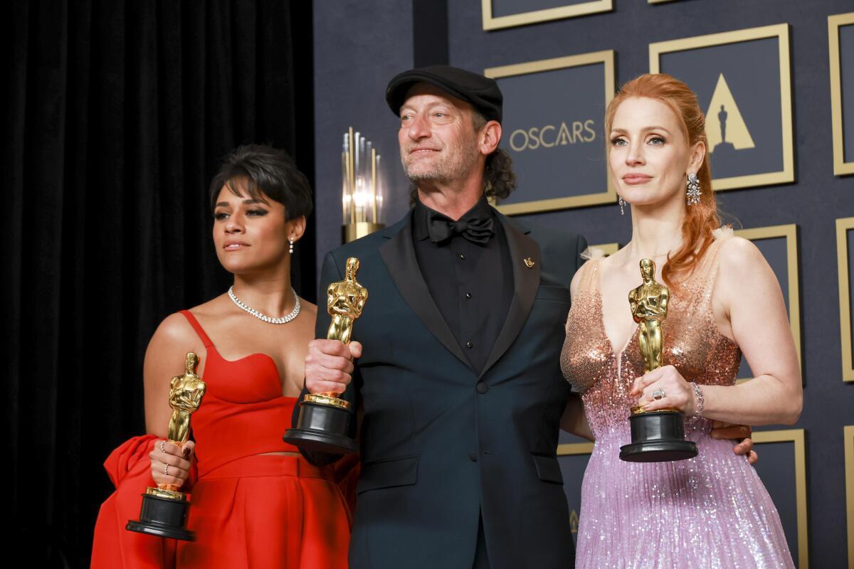 Three Oscar winners hold statuettes.
