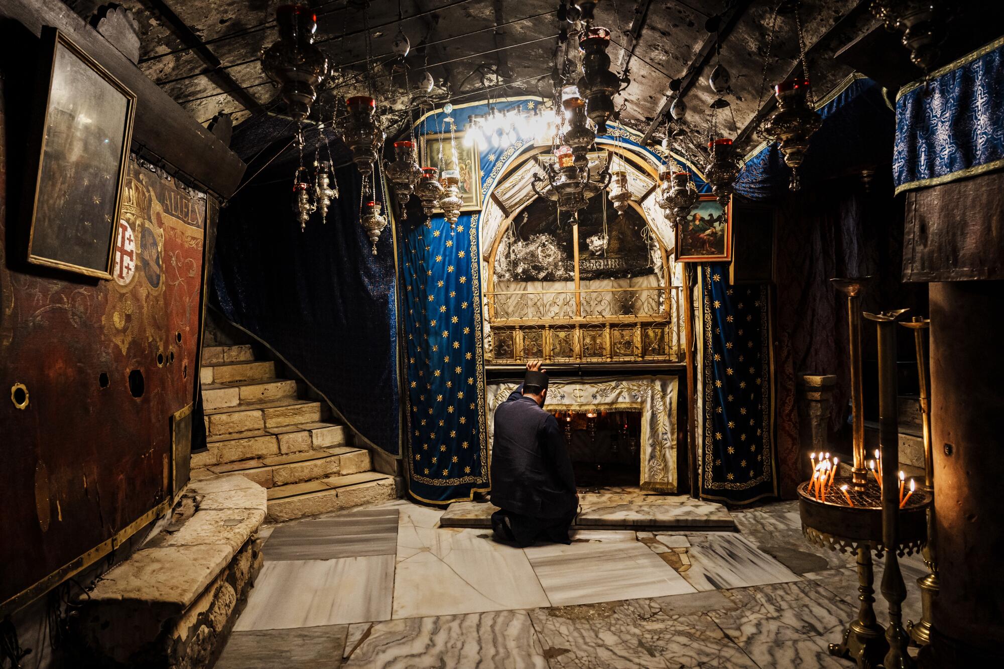A man kneels in an underground area of the Church of the Nativity in Bethlehem.