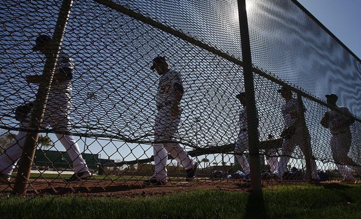 When the Dodgers go from spring training workouts to exhibition games, only a handful will be seen on television. Above, Dodgers players take to the practice field Sunday at Camelback Ranch in Phoenix.