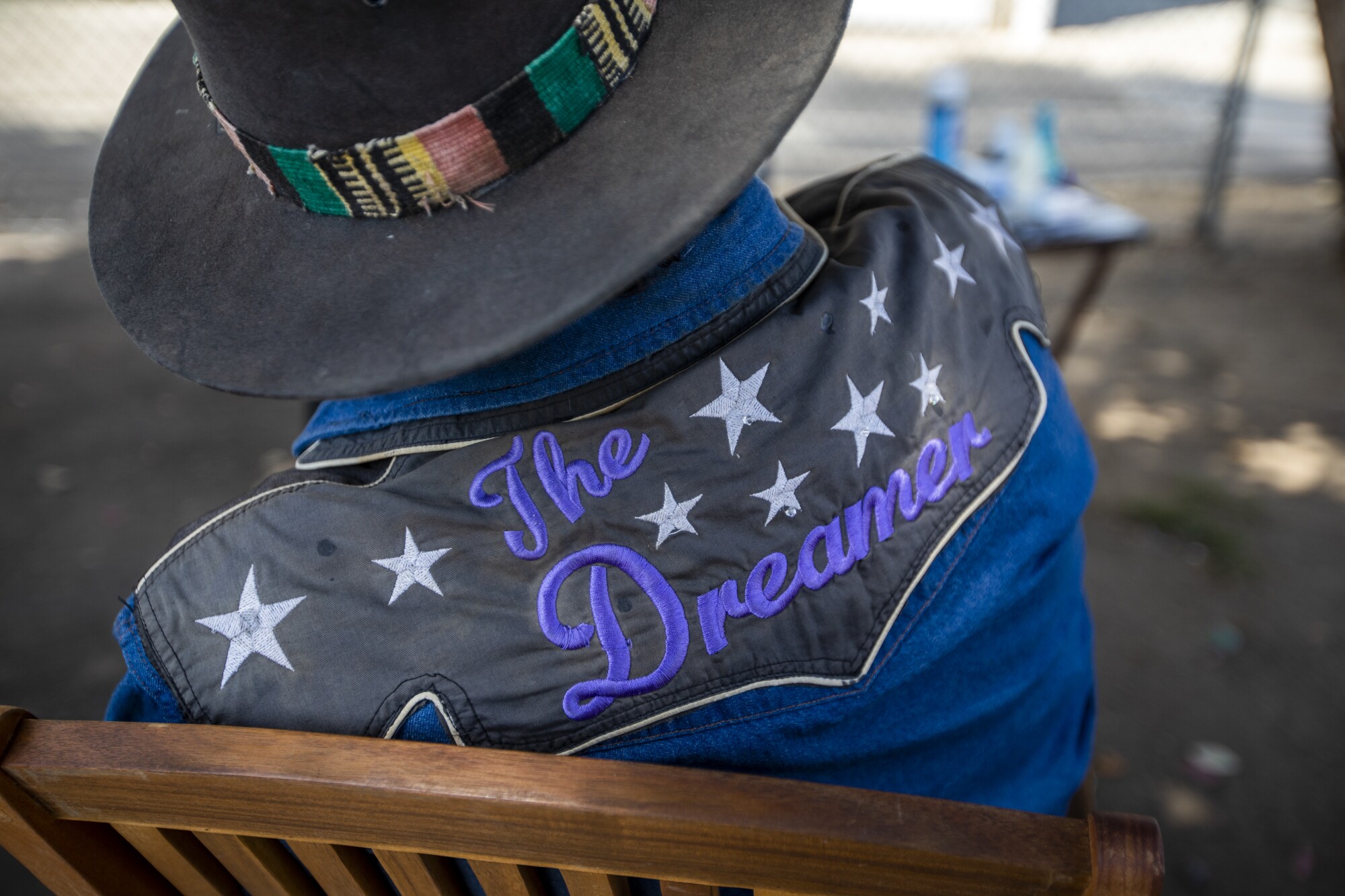 Bravo, known as "Dreamer," sits in the shade of two eucalyptus trees and waits for customers for haircuts.