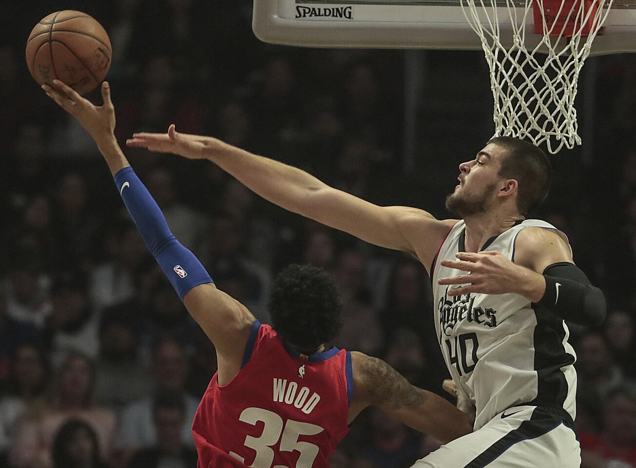 Detroit Pistons forward Christian Wood, left, strains to shoot over Clippers center Ivica Zubac during the first half.