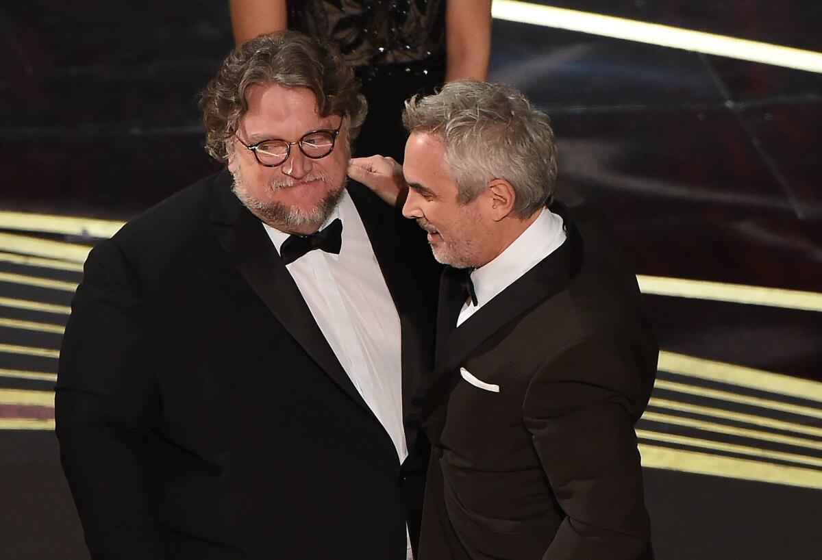 Alfonso Cuarón acepta su premio como Mejor Director de manos de su compatriota Guillermo Del Toro en el Dolby Theatre de Hollywood, California.