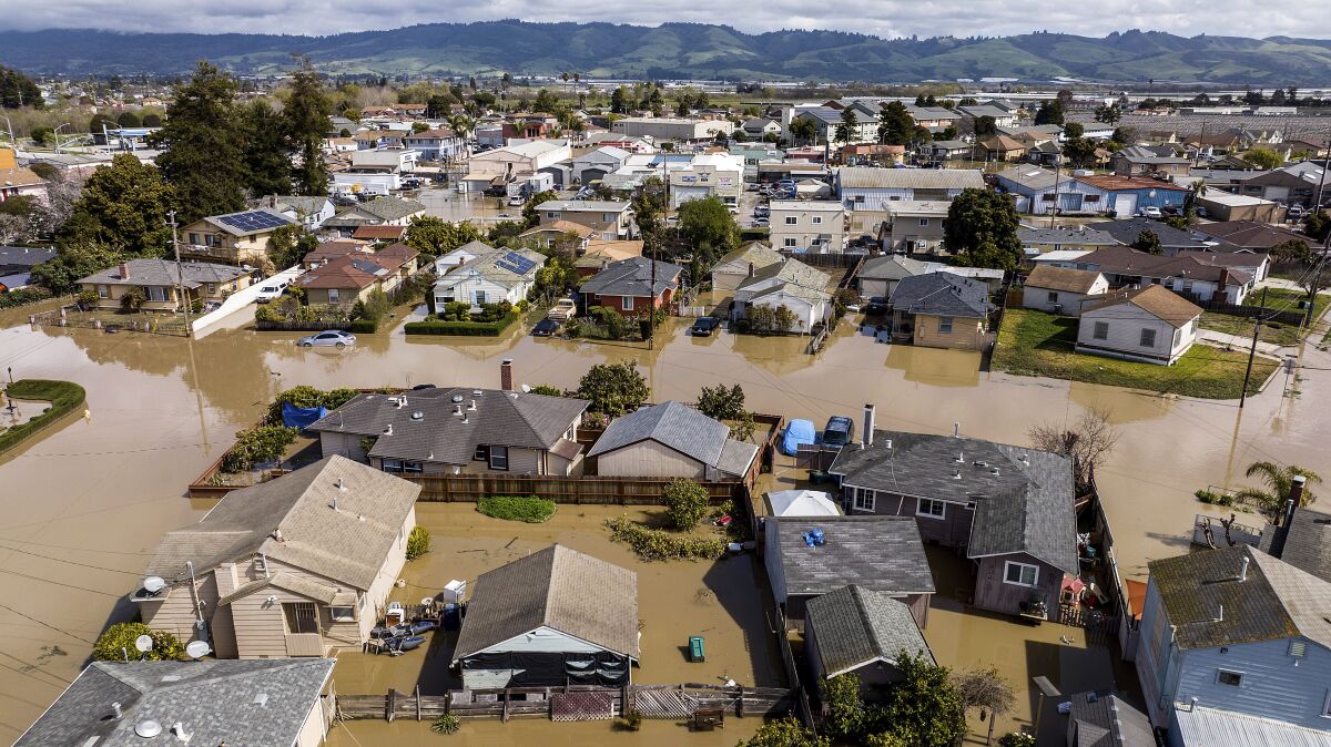 Floodwaters surround homes and vehicles in Monterey County, Calif.