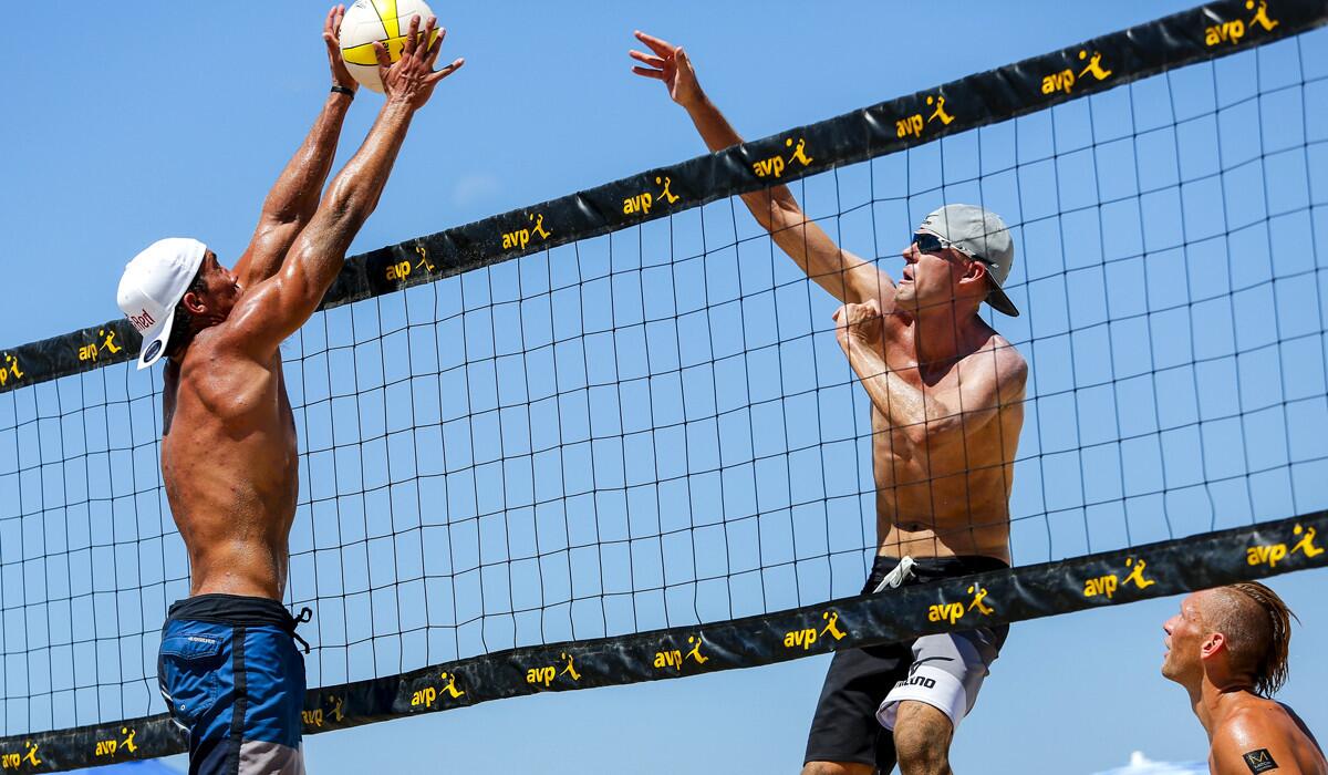 Trevor Crabb gets his hands on the hit of Jake Gibb during his third-round win with teammate Billy Allen over Gibb and Casey Patterson, at the AVP Manhattan Beach Open of volleyball, Aug. 16, 2014.