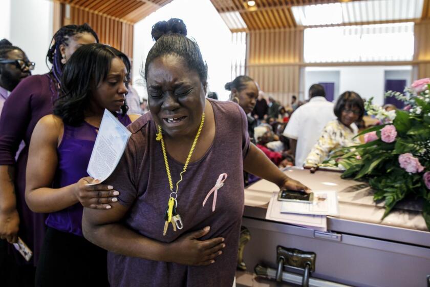 HACIENDA HEIGHTS, CALIF. -- MONDAY, MARCH 25, 2019: Asunoya Sanni, walks away in tears after touching the casket for Trinity Love Jones, during the community "Memorial of Light" service for her, at St. John Vianney Parish in Hacienda Heights, Calif., on March 25, 2019. (Marcus Yam / Los Angeles Times)