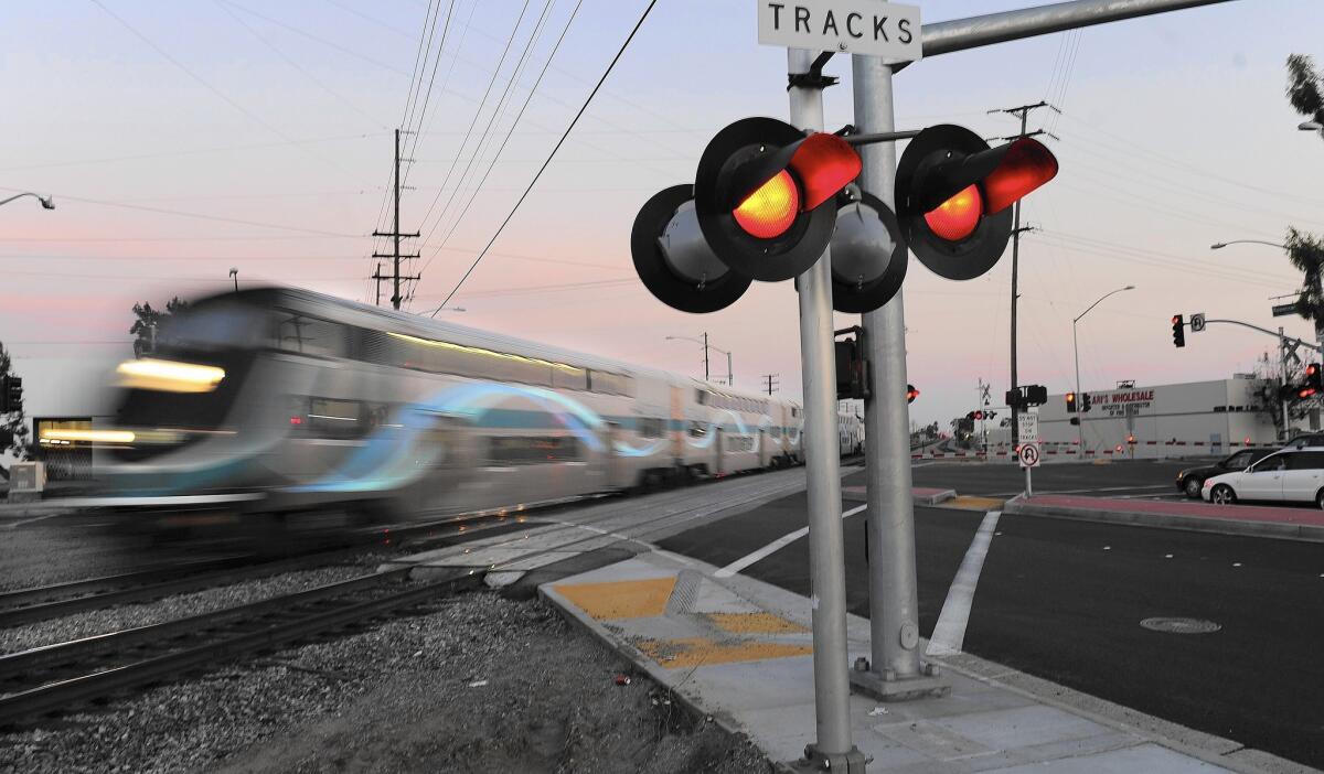 A Metrolink train at the intersection of Rosecrans Avenue and Marquardt Avenue in Santa Fe Springs. The agency's purchase of powerful new locomotives is part of a broader program to improve customer service and rebuild ridership that has been lost since 2008.
