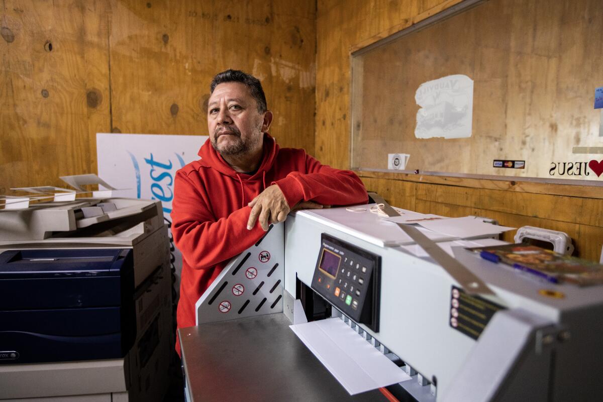 A man leans against a printer