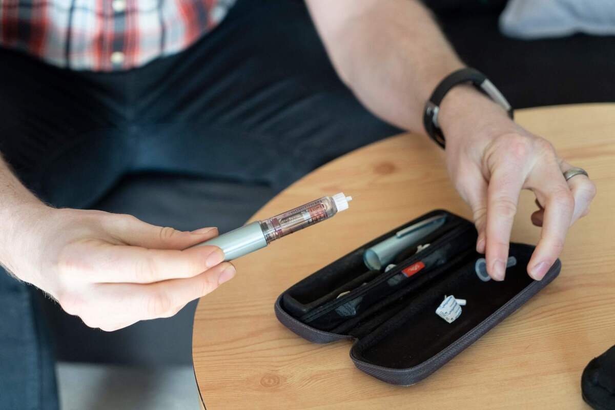 David Burns, de 38 años y quien padece diabetes tipo 1, prepara su insulina para inyectarse en casa.