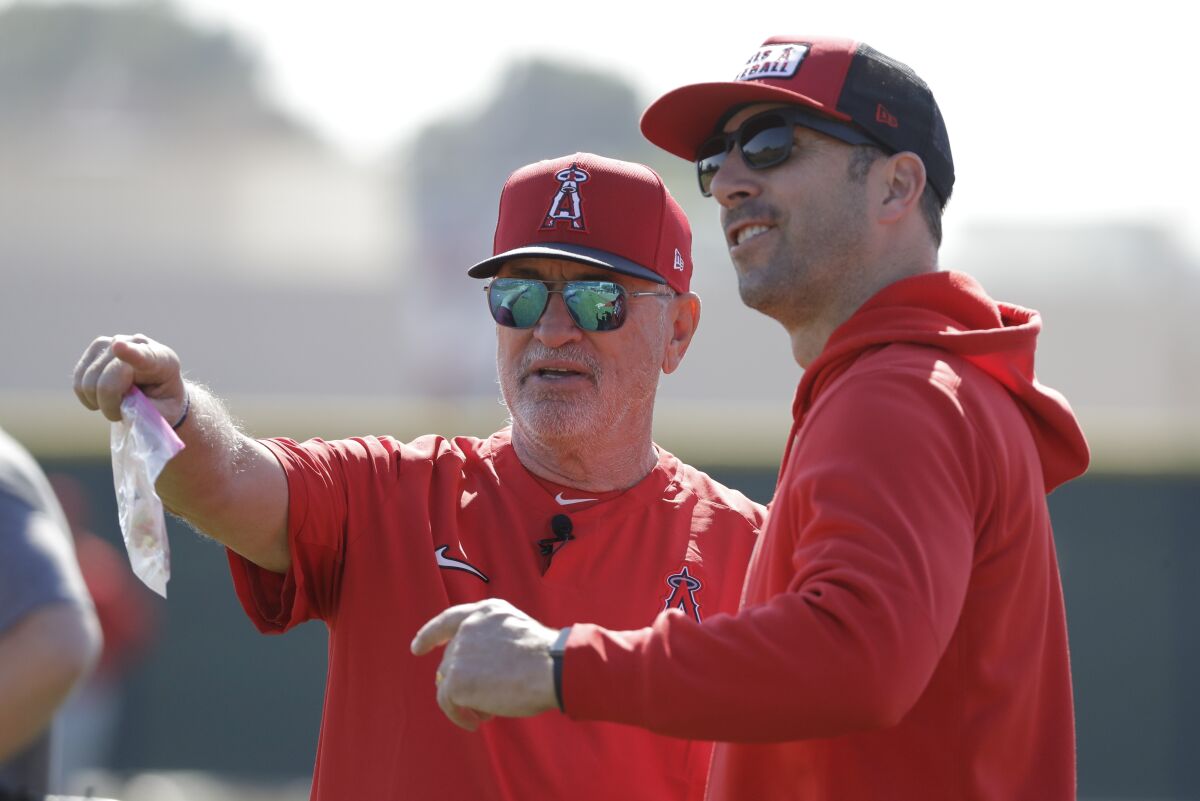 Angels manager Joe Maddon talks with general manager Billy Eppler during spring training on Feb. 17 in Tempe, Ariz.