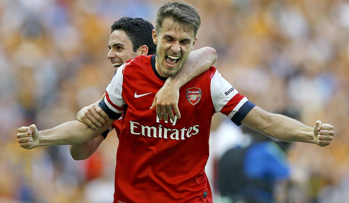 Arsenal's Aaron Ramsey celebrates with teammate Mikel Arteta after winning the FA Cup championship game against Hull on Saturday at Wembley Stadium in London.