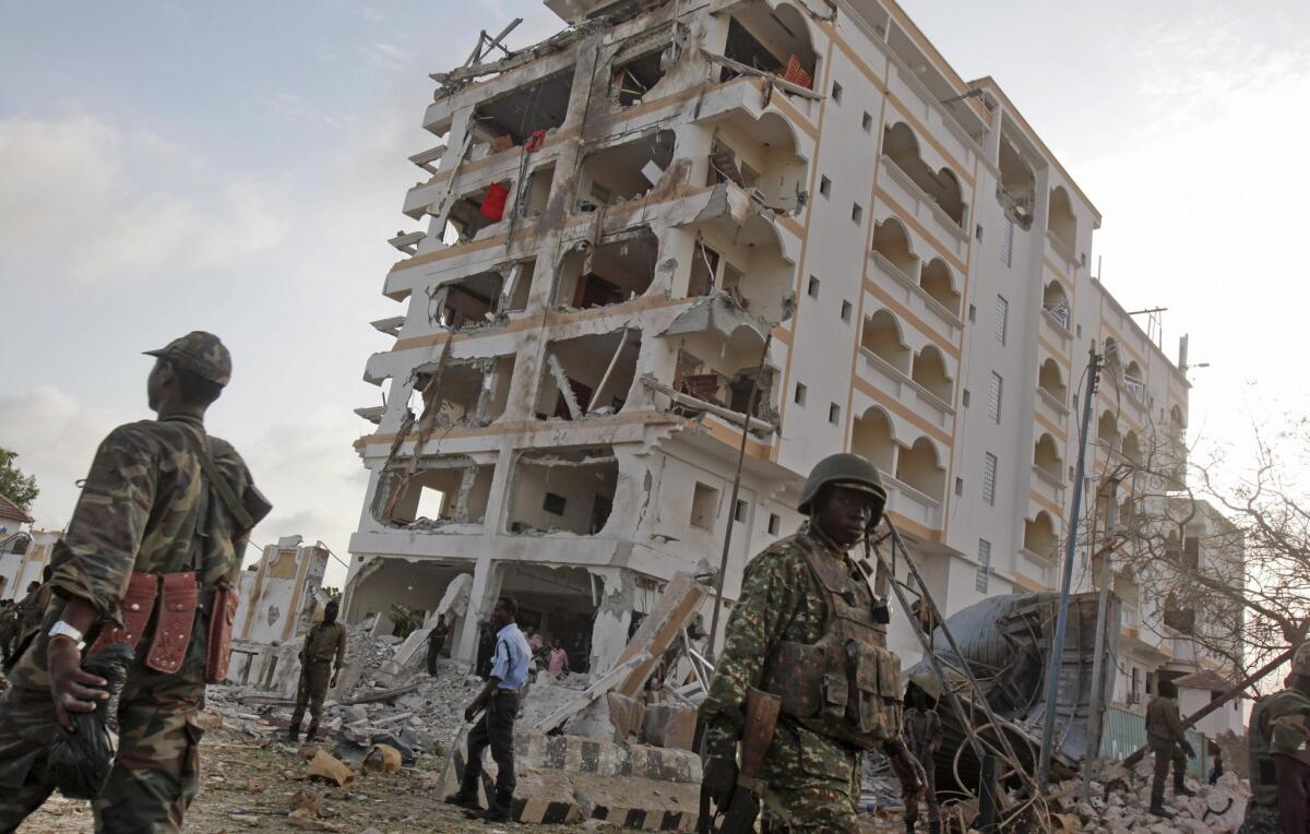 African Union soldiers walk past the scene of a suicide car bomb attack in Mogadishu, Somalia, on Sunday.