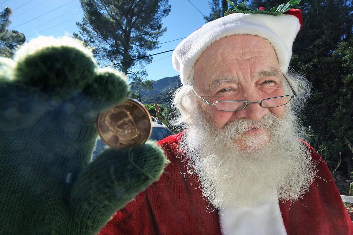 La Crescenta resident Joe Mandoky dresses up every year as Santa and hands out golden dollars to people who say they believe in Santa Claus. Photographed on Monday, December 23, 2013.