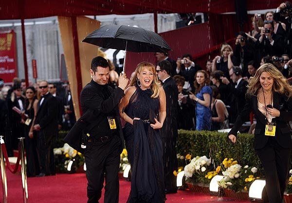 An Oscars attendant helps Virginia Madsen stay dry as she arrives at the 82nd annual Academy Awards on Sunday at the Kodak Theatre in Hollywood.