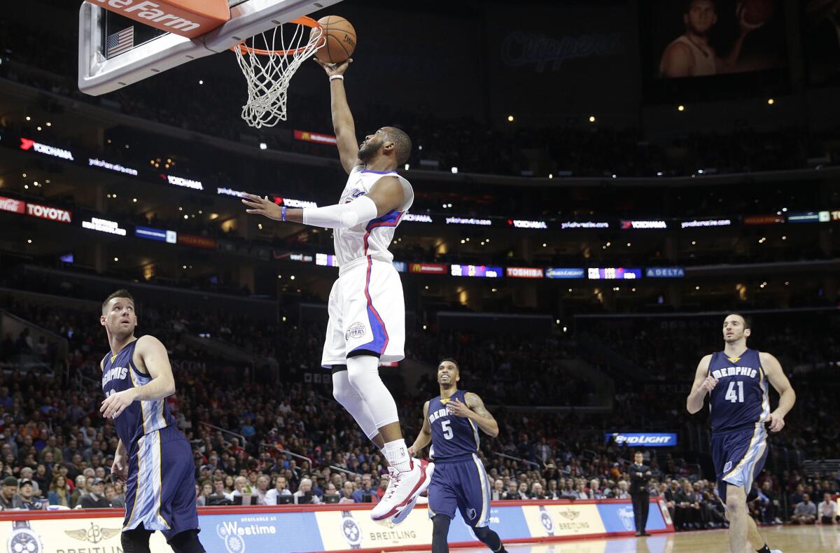 Clippers point guard Chris Paul makes a layup while three Grizzlies look on during the first half on Monday.
