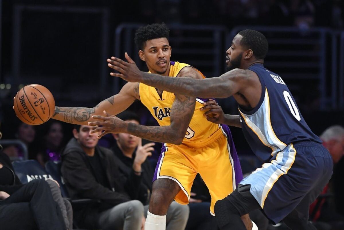Lakers guard Nick Young, left, tries to pass while under pressure from Memphis Grizzlies forward JaMychal Green during a Jan. 3 game.