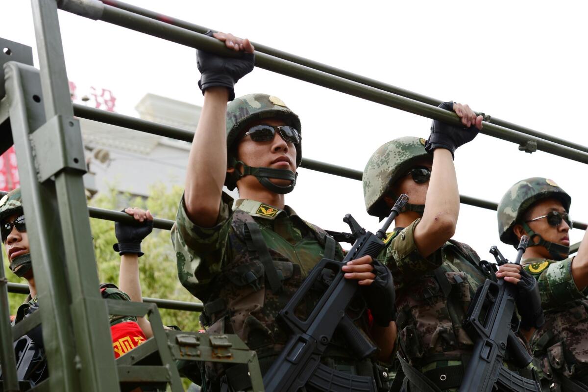 Security forces participate in a military drill on June 6 in Hetian, northwest China's Xinjiang region. China reported the deaths of 13 police and 20 others during weekend clashes in the province.