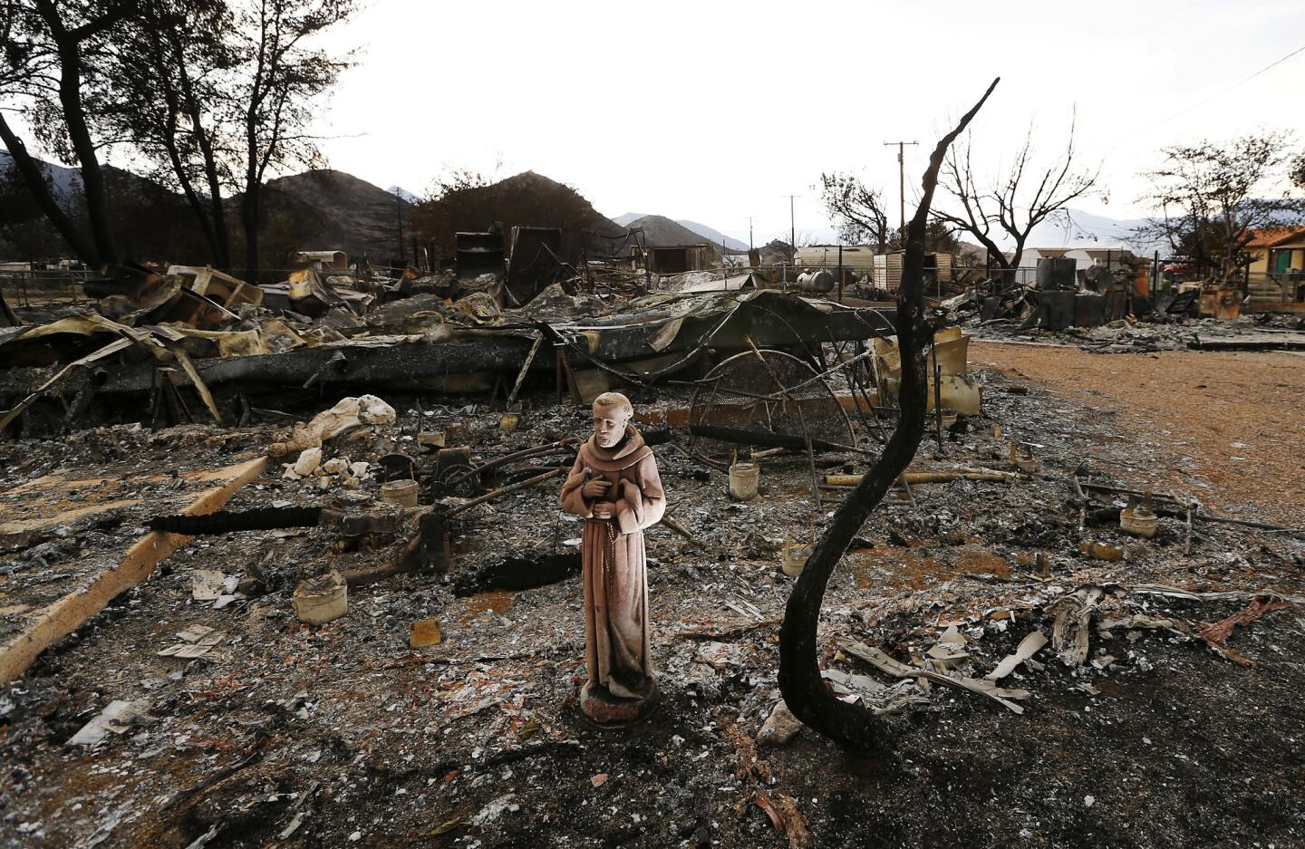 A religious icon stands in the charred remains of a neighborhood in South Lake.