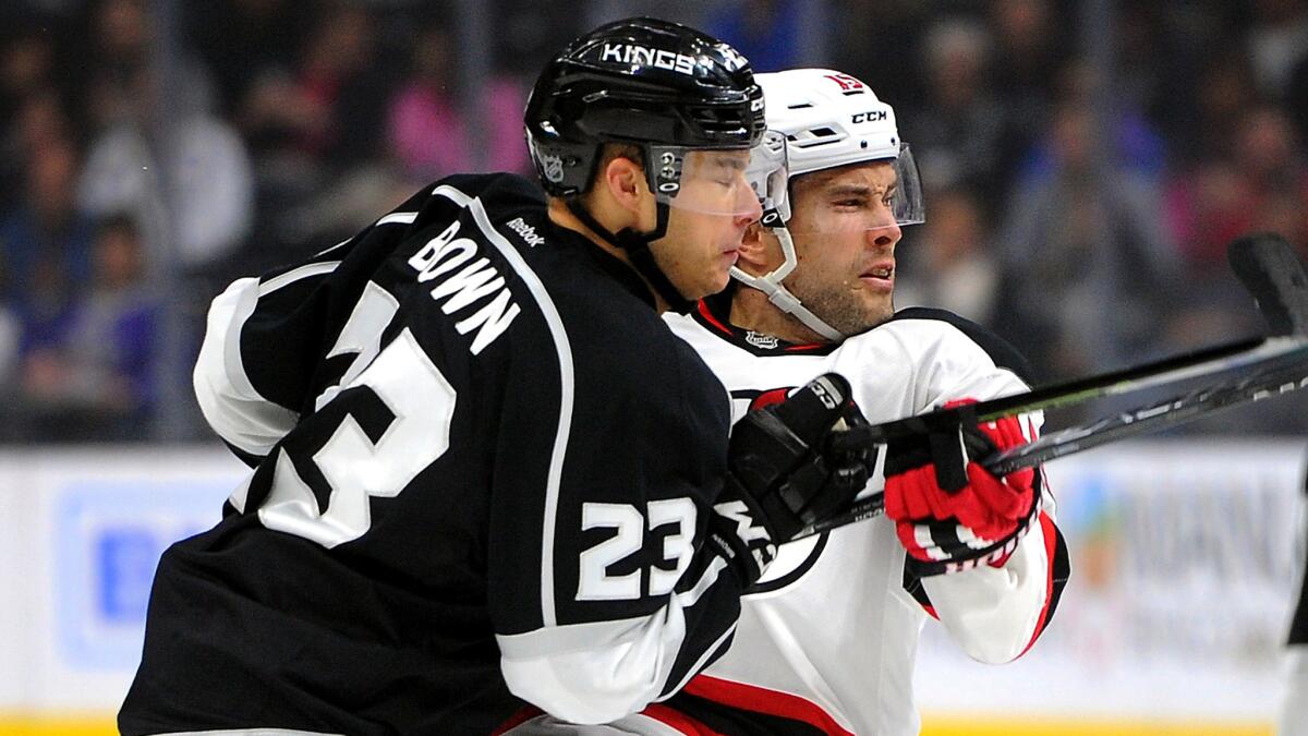 Kings right wing Dustin Brown checks Devils left wing Tuomo Ruutu during the first period Saturday.