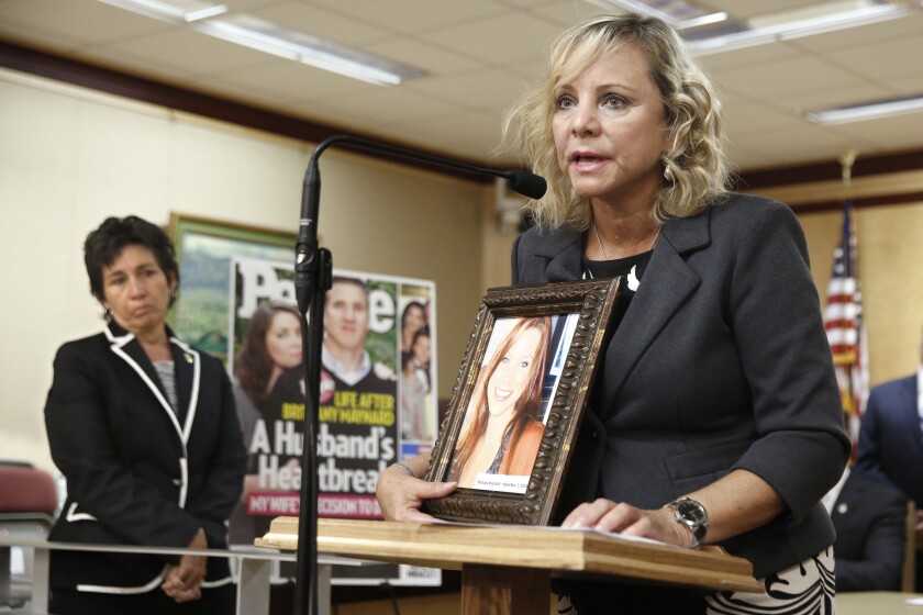FILE — Debbie Ziegler holds a photo of her daughter, Brittany Maynard, the California woman with brain cancer who moved to Oregon to legally end her life, during a news conference to announce the reintroduction of right to die legislation, Tuesday, Aug. 18, 2015, in Sacramento, Calif. An appeals court formally ended a lawsuit, Monday, Nov. 1, 2021, that in 2018 temporarily suspended a law by then-Assemblywoman Susan Talamantes Eggman, D-Stockton, left, that allows adults to obtain prescriptions for life-ending drugs. (AP Photo/Rich Pedroncelli, File)