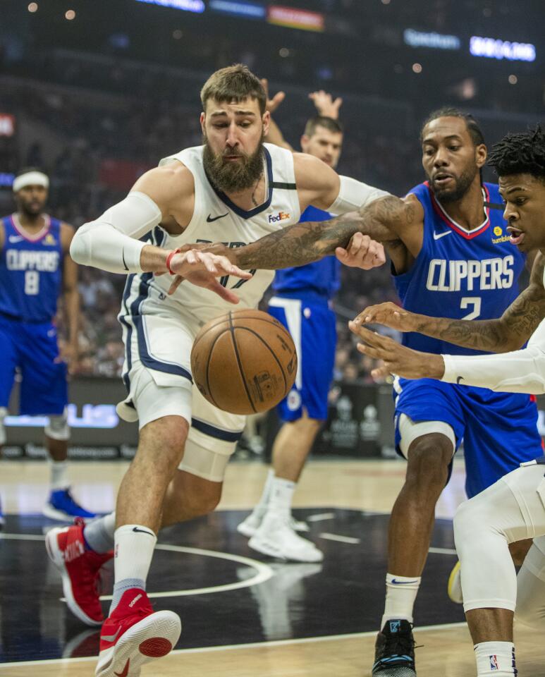 LOS ANGELES, CALIF. -- SATURDAY, JANUARY 4, 2020: Memphis Grizzlies center Jonas Valanciunas, left, and forward Ja Morant, right, battle Clippers forward Kawhi Leonard for a rebound during the first half at the Staples Center in Los Angeles, Calif., on Jan. 4, 2020. (Allen J. Schaben / Los Angeles Times)