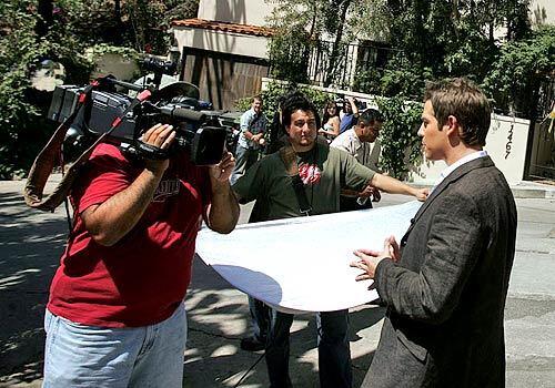 Jason Kennedy of E! Entertainment files a report outside Paris Hilton's Hollywood Hills home.
