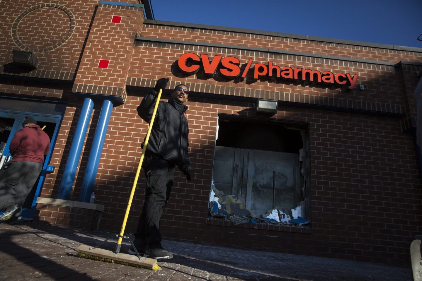 People clean up outside a CVS pharmacy in Baltimore after the pharmacy was set on fire in the wake of protests for the death of Freddie Gray.