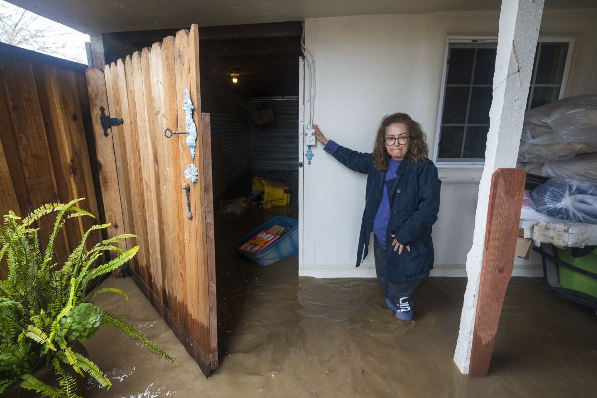 Teresa Fuentes becomes emotional after seeing flood damage to her belongings at her home on College Road in Watsonville, California.