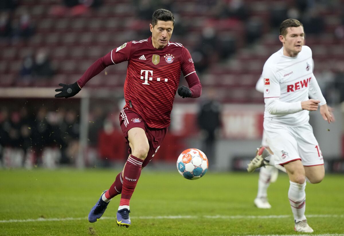 Bayern's Robert Lewandowski attacks with the ball during the German Bundesliga soccer match between 1.FC Cologne and Bayern Munich in Cologne, Germany, Saturday, Jan. 15, 2022. (AP Photo/Martin Meissner)