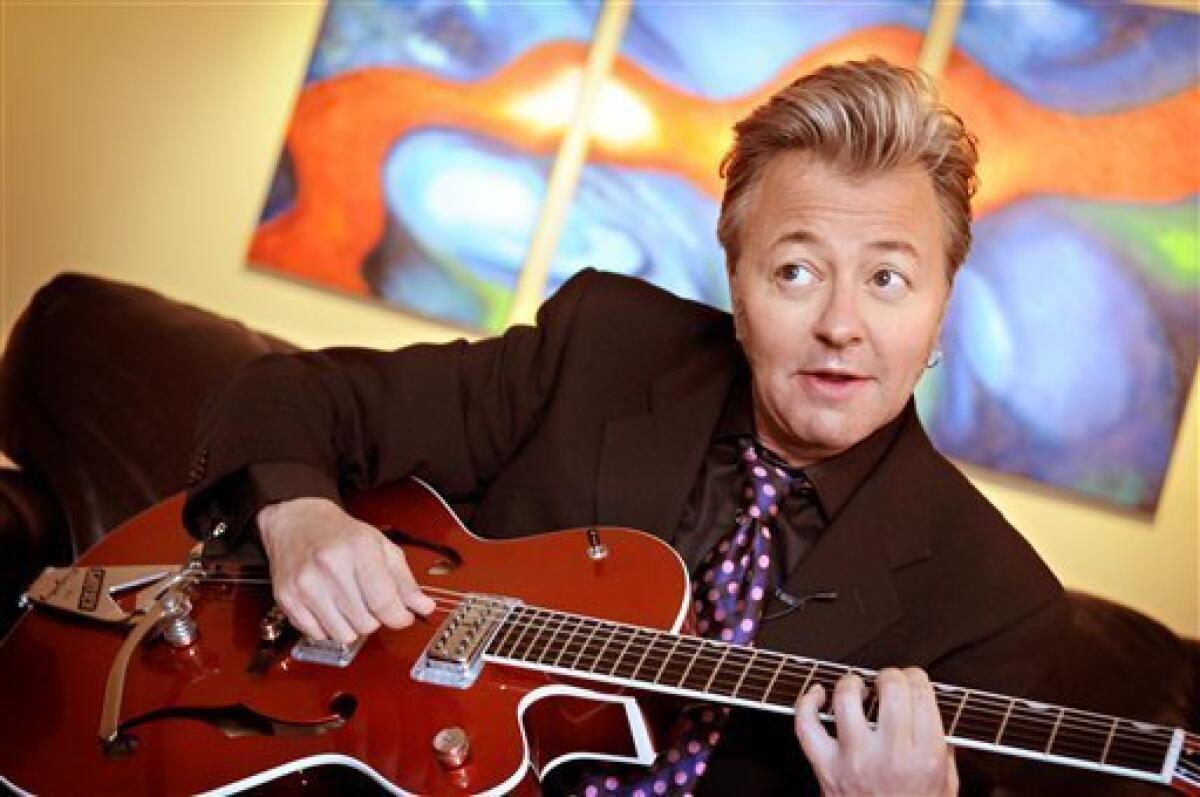 FILE - Veteran solo artist and former Stray Cats' guitarist/singer Brian Setzer poses at home with his guitar in Minneapolis. (AP Photo/Dawn Villella, file)