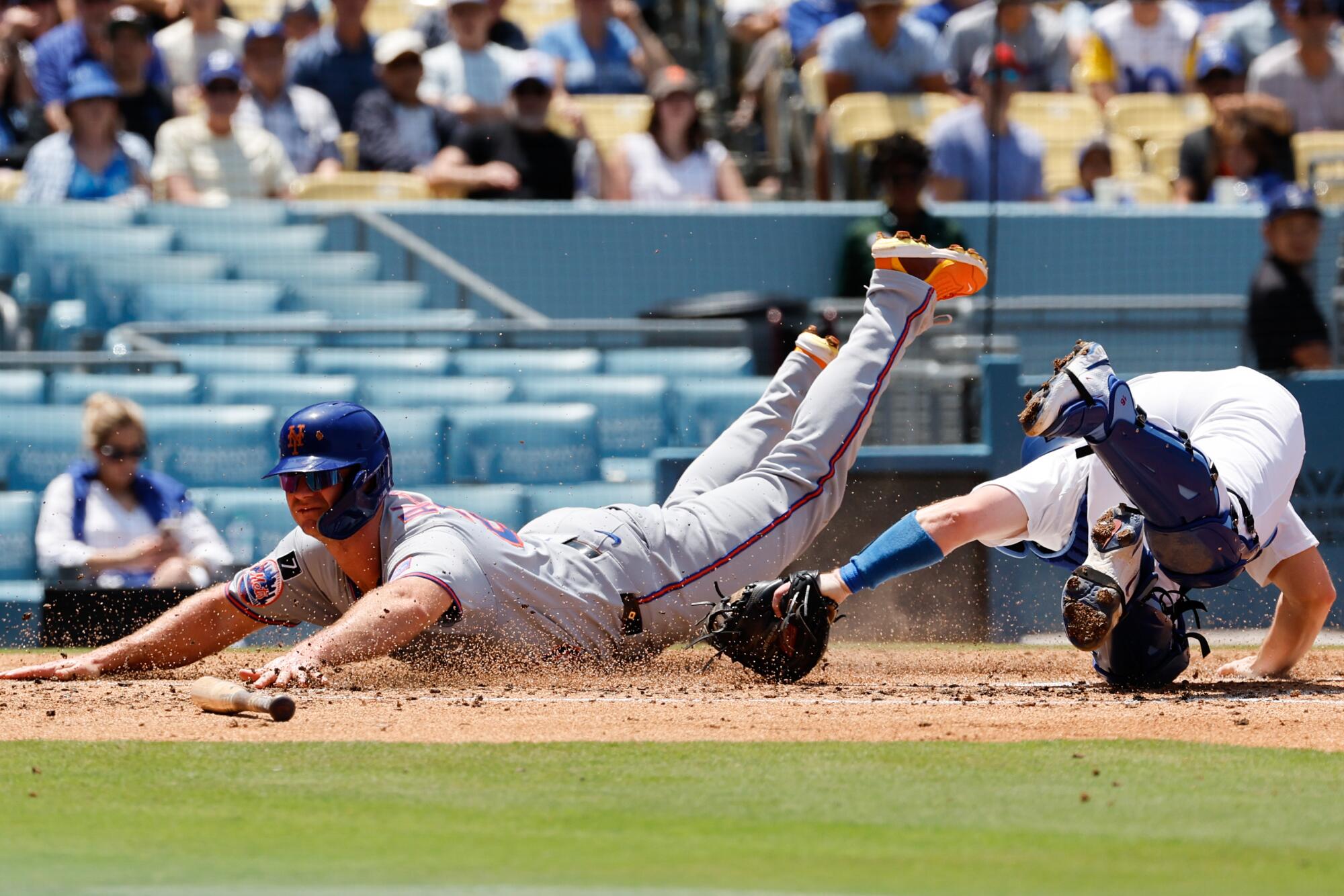 Pete Alonso slides past Dodgers catcher Will Smith to score a run for the Mets in the third inning Thursday.
